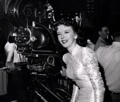 a black and white photo of a woman in front of a camera