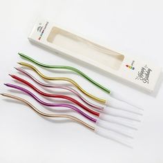 four different colored toothbrushes in a box and one is empty with the lid open