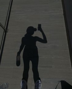 the shadow of a person holding a beer bottle