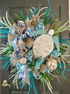 This beautiful turtle wreath is surrounded by the blue and green colors of tropical waters.  Wood and metal sea turtle, artificial fillers and a matching bow. This wreath is on a pine base lined with mesh for fullness.  36x37x10 Sea Turtle Wreath, Beach Theme Wreath, Coastal Wreaths Front Doors, Beach Wreath Ideas, Turtle Wreath, Seaside Wreath, Coastal Wreaths, Seashell Decorations, Beachy Christmas Decor