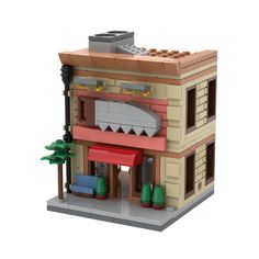 a lego model of a building with trees on the front and windows, including a red awning