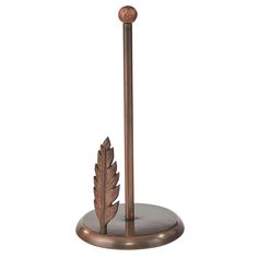 a metal pole with a leaf on it and a ball at the top, in front of a white background