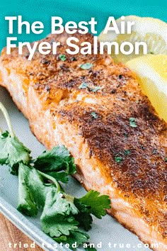 the best air fryer salmon on a plate with lemon wedges and parsley