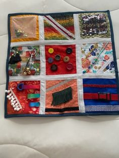 a close up of a quilt on a bed with buttons and other things in it