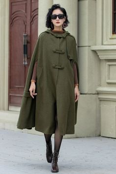 Crafted with the utmost attention to detail, this versatile cape exudes elegance and warmth. The military green color complements any outfit, making it suitable for both casual outings and formal occasions. DESIGN FEATURES * 30% Wool blend, 70% fiber nylon * Polyester lining * Double breasted buttons * Two side pockets * Hooded wool cape * Loose fit cape * Mid-calf length effect * Autumn winter cape coat * Dry Clean or Hand Wash in Cold Water MODEL SIZE Bust 85 cm(33.4") Waist 67 cm(26.7") Heigh Solid Hooded Cape For Fall, Hooded Green Cape For Fall, Green Hooded Cape For Fall, Green Winter Cape Outerwear, Oversized Wool Cape Coat For Fall, Hooded Wool Cape For Winter, Oversized Solid Color Cape Outerwear, Green Cape Outerwear For Fall, Oversized Winter Cape