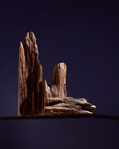 two pieces of wood sitting on top of a wooden table under a dark blue sky