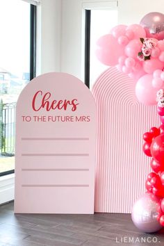 pink balloons are in the air near a sign that says cheers to the future mrs