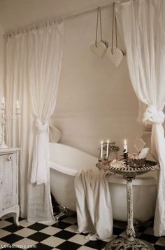 a white bath tub sitting next to a black and white checkered floor