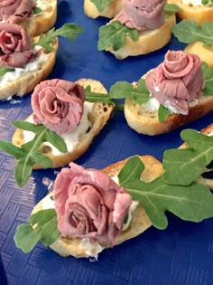 small sandwiches with flowers on them sitting on a blue tray