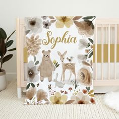 a baby crib next to a potted plant and a white wall with the name sophha on it