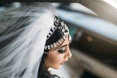 a woman in a car wearing a bridal veil and diamond jewelry on her head