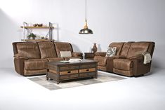 a living room with two couches and a coffee table in front of a white wall