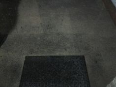 a black door mat sitting on top of a sidewalk