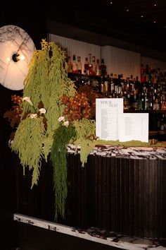 there is a table with menus on it in front of the bar and liquor bottles