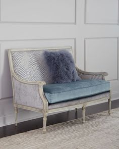 a chair with a blue cushion on it in front of a white paneled wall