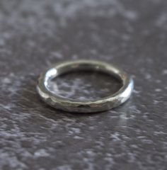 This is a classic band made in solid sterling silver. It has a hammered finish which is tactile and catches the light beautifully.  The ring is size O (centre) and it is constructed from round silver wire measuring approximately 2.6mm in diameter. Its approximate weight is 4.4g. The ring is hallmarked inside. I have also created some matching items which would look fabulous worn together as a set. https://www.etsy.com/uk/listing/266945656/silver-torque-bangle-hammered https://www.etsy.com/uk/lis Modern Sterling Silver Hammered Rings, Silver Stackable Rings With Hand Forged Round Band, Modern Hammered Stackable Rings, White Gold Hammered Round Ring, Classic Sterling Silver Hammered Ring, Minimalist Silver Engraved Ring With Hammered Detail, Minimalist Silver Hammered Engraved Ring, Minimalist Hammered Silver Engraved Ring, Hammered White Gold Ring With Round Band