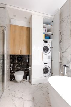 a bathroom with marble walls and flooring next to a bathtub in the corner