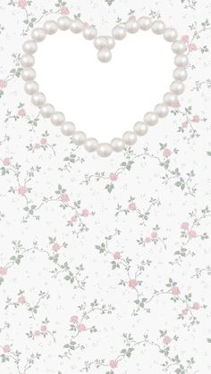 a heart shaped frame with pearls and flowers on the wall behind it is an empty space for