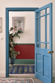 an open door leading into a room with pictures on the wall and potted plant