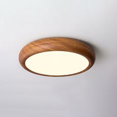 a circular wooden light fixture on a white wall