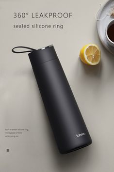 thermos is sitting next to a cup of coffee and an orange on a table