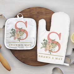 two personalized oven mitts on top of a cutting board with lemons and utensils