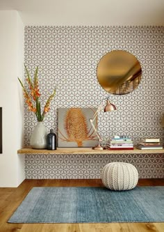 a living room with a blue rug and wooden flooring next to a wall mounted mirror