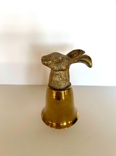 a gold colored rabbit shaped object sitting on top of a table