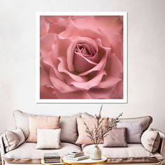 a living room with a couch, coffee table and large pink rose on the wall