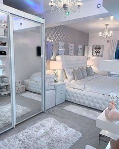 a white bedroom with mirrored walls and chandelier hanging from the ceiling, carpeted flooring