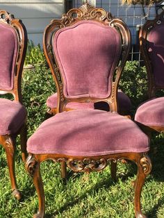 four antique chairs with pink velvet upholstered on them in the grass near a house