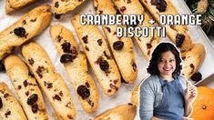 a woman standing in front of a tray of cranberry and orange biscotti