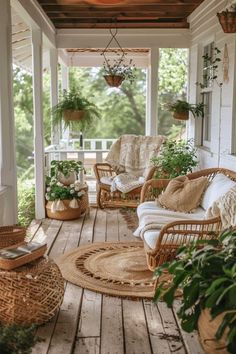 a porch with wicker furniture and potted plants on the front porch, which is covered in wood planks