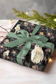 a gift wrapped in black and green wrapping paper with an owl design