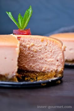 a piece of cheesecake on a plate with a strawberry garnish in the middle