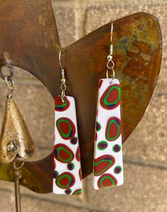 These fun boho style earrings come in 2 sizes. Each pair has different coloured dots randomly arranged on the earring. They have a slight texture to them. They are bright and fun. All of my earrings are handmade using Polymer Clay which keeps them very light to wear. No 2 pairs are ever the same and as they are hand made they may have very slight imperfections but that is the beauty of handmade. I take care to represent the true colour of the earrings. I hope you love wearing the earrings as much as I loved making them. Funky Drop Earrings With Ear Wire, Handmade Funky Dangle Earrings, Funky Green Earrings As A Gift, Funky Green Earrings For Gift, Handmade Funky Colorful Earrings, Colorful Handmade Funky Earrings, Colorful Funky Handmade Earrings, Playful White Earrings With Ear Wire, Playful Multicolor Ear Wire Earrings