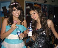 two young women standing next to each other holding water bottles and toothbrushes in their hands