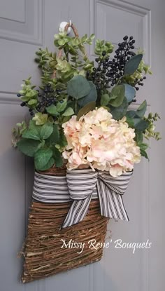 a basket filled with flowers sitting on top of a door