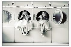 two women sitting in front of washing machines