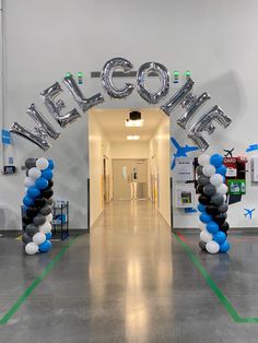 the entrance to an office with balloons in the shape of letters that spell out welcome