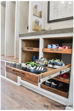 two wooden shelves with shoes in them on top of a hard wood floor next to a white wall