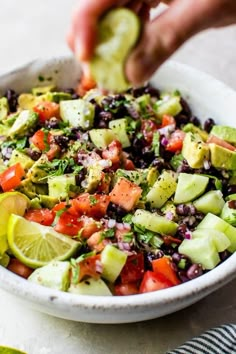 a person is dipping an avocado into a salad