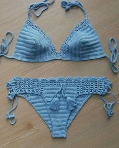 two pieces of blue crochet swimsuit on a wooden surface