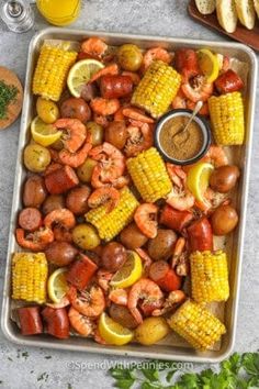 shrimp, lobster, corn on the cob and potatoes are served in a casserole dish