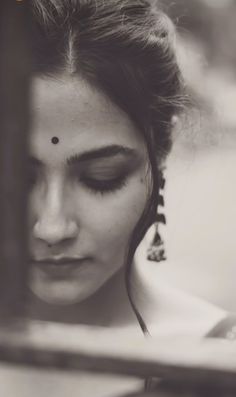 a woman with her eyes closed looking through a window