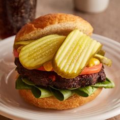 a hamburger with pickles and tomatoes on it