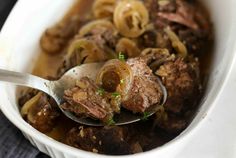 a white bowl filled with meat and noodles