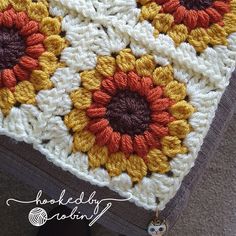 a crocheted blanket with sunflowers on it and a keychain