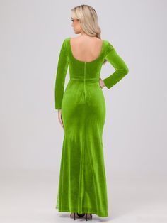 a woman in a green dress with her back turned to the camera, looking down