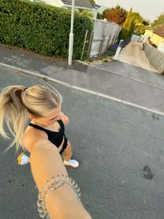 a woman is walking down the street with her hair in a pony tail and braid